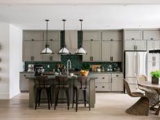 The open-concept kitchen has a woodsy chic vibe with a rich color palette of brown, gray and forest green inspired by the outdoors.
