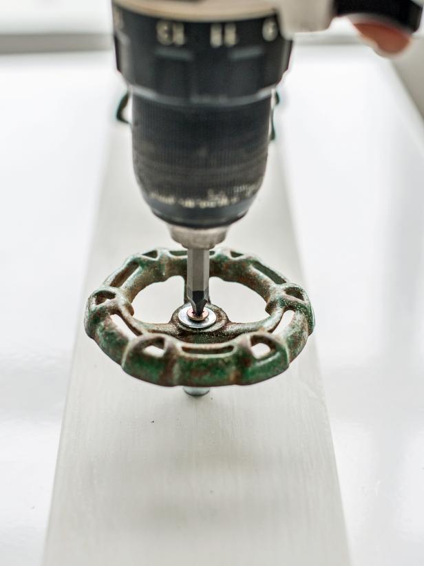 Place screw tip on pencil mark and drive self-boring screw in with a drill. Repeat with four other spigot handles. Hang on wall by nailing or screwing into studs or by installing d-rings on back of board.