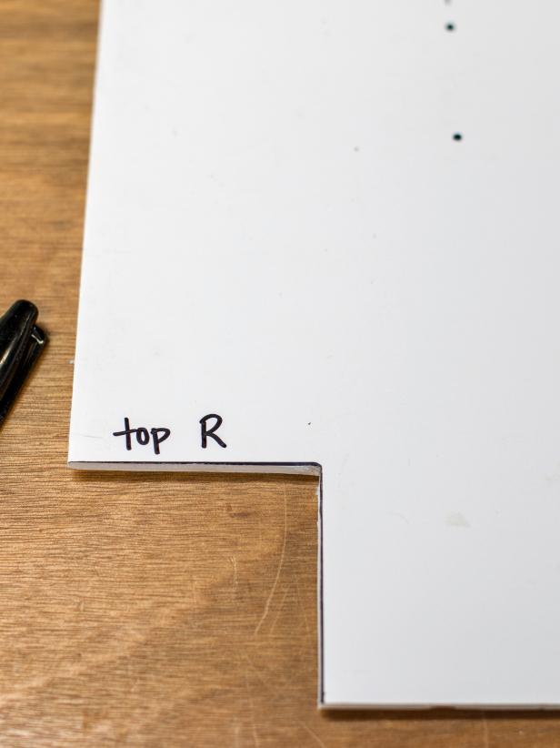 Pretending that the “notch” is the top right corner of the window trim, position curtain rod bracket on template in desired location in relation to trim.