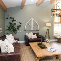 Soft Green Living Room With Natural Wood Details, Brown Leather Sofas and Distressed Art