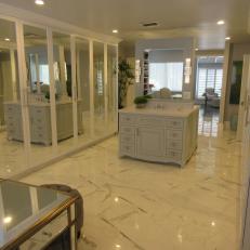 Large Walk-In Closet With Pronounced Marble Floor Tile, Mirror Closet Doors and Elegant Vanity With Lighted Mirror 