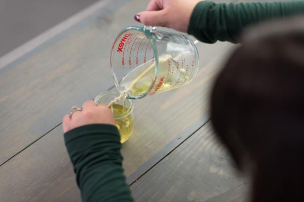 Pouring Melted Wax Into Glass Jar With Wick