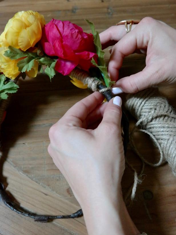 Starting at the top, beneath the flowers, tie a small knot of twine. Next, working your way around, wrap the floral-taped wire with twine to give the flower crown a finished, rustic look. Finish with a second knot close to the first (also under the blooms) in order to hide the ties.