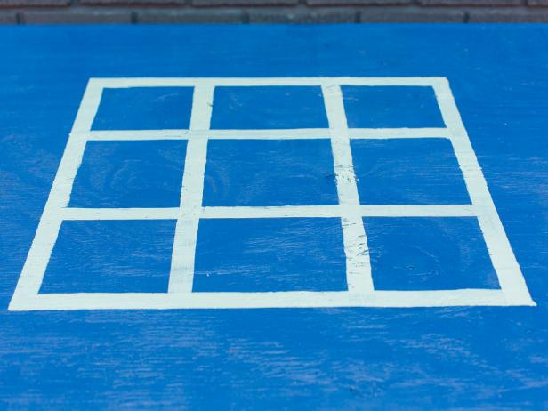 Next, with a lighter paint- we used aqua, using the 6 inch and 14 inch marks as a guide, free hand lines with 1” foam paint brush to create the grid. It’s okay if they’re not perfect, that’s part of the handmade charm! Once dry, remove the tape