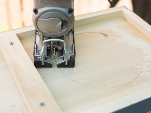 Trace a circle to accommodate your particular ice bucket. To get started with your cut, you’ll need to use a drill with a large bit to make a pilot hole, then insert your jig blade and cut the hole out. Cut the circle out just inside the traced line so that ice bucket fits snug.