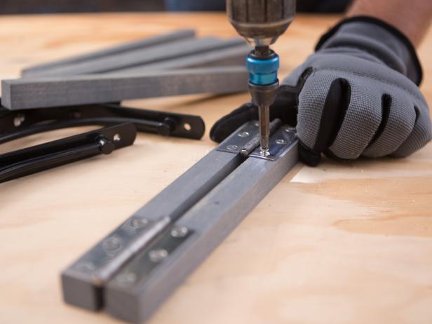 Next, attach two sections of the ¾” dowel together using the stainless hinges. Repeat this three times. Then attach the shelf brackets to these so that they sit flush. This way once they’re installed, they’ll easily swing in and out, as needed when you lift the bar up. When not in use, they’ll lay flat against the wall.