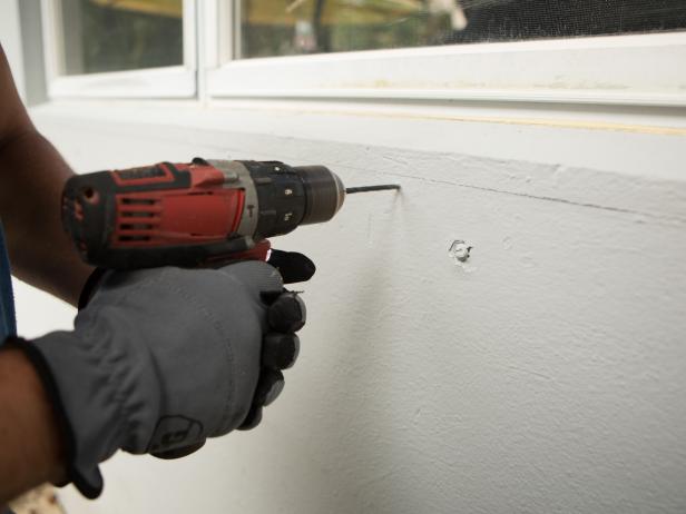 Now you’re ready to attach the bar to the house. Begin by marking where the bar will go with a level. Next, pre-drill and add any necessary anchors depending on what type of exterior cladding your home has, in our case we used heavy duty concrete anchors to secure the bar to the house.