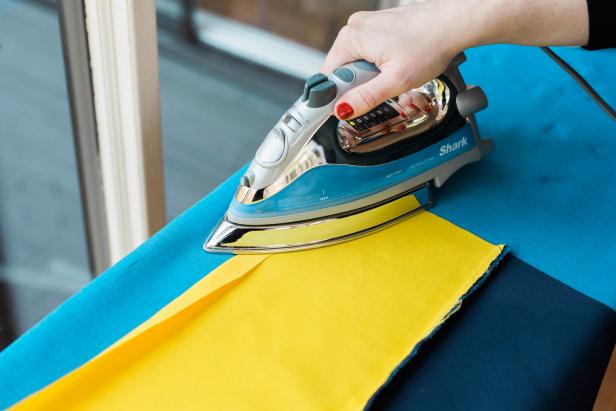 Fold, then iron a hem to the flap edge on the flag. Sew it in place, using a straight stitch.