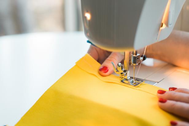 Fold, then iron a hem to the flap edge on the flag. Sew it in place, using a straight stitch.