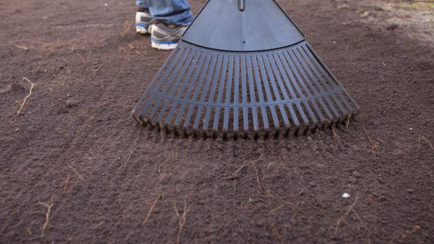 Next, using a shovel, prep the area by digging down at least 6 inches to remove any grass, roots or large rocks. Rake the area out, then tamp down flat with a hand tamper