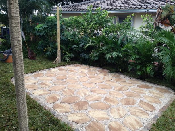 Once the area is dry, pour pea gravel out in small sections and sweep across the surface of patio until the gaps between pavers and border stones are filled and level