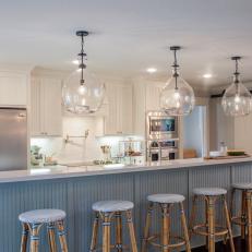 Bright Blue and White Kitchen With White Barn Doors, Large Island and Wicker Bar Stools 