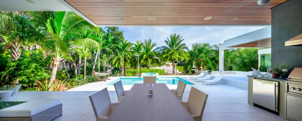 Dining Area and Outdoor Kitchen with Pool View Dining Area and Outdoor Kitchen with Pool View and Palm Trees