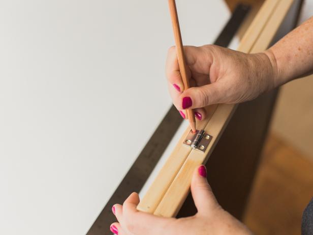 Line up the two chalk boards back-to-back, then mark the location of the two hinges four inches from the outside edge.