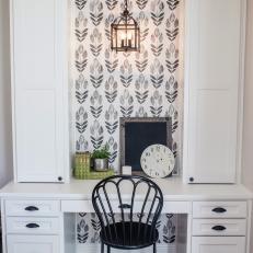 Built In Desk With White Cabinetry, Black Pendant Lantern and Patterned Black and White Wallpaper 