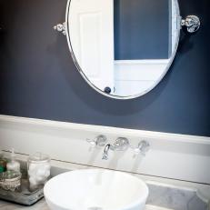 White Contemporary Vessel Sink on Gray Marble Countertop Beneath Dark Navy Accent Wall in Bathroom 