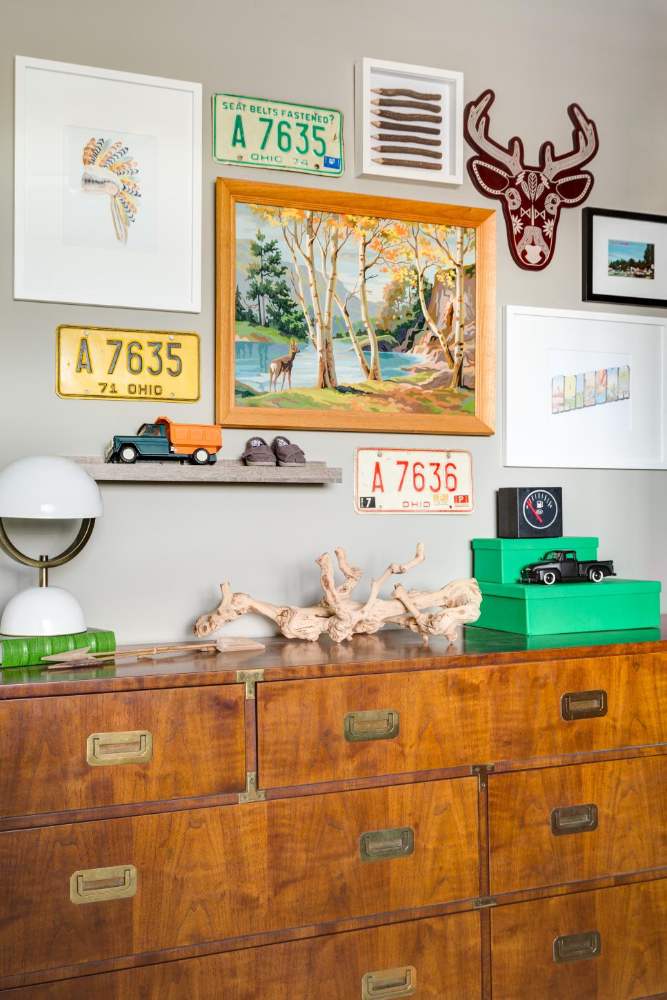 Old License Plates and Outdoorsy Art Blend Well with a Modern Campaign Chest of Drawers Mix of auto and outdoor artwork above modern dresser in boy's bedroom.