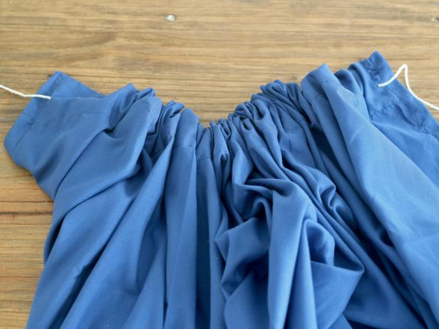 Thread the rope all the way through the top hem of the sheet to the top right corner. Gather the sheet on the rope as you go.