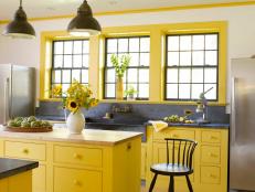 Interior Designer Heide Hendricksâ   color sense hits the perfect pitch in this kitchen. â  The surrounding meadows filled with Goldenrod and Black-Eyed Susan helped choose the colors,â   she says. Hendricks collaborated with her husband Rafe Churchill on this country home for a family of four. Cabinetry painted in Farrow & Ballâ  s â  Baboucheâ   yellow compliments the dark grey of custom-fabricated soapstone sink and counters. Added to the softly textured white of rubbed plaster walls and ceilings, and vintage plumbing and light fixtures, the space feels traditional, yet fresh.