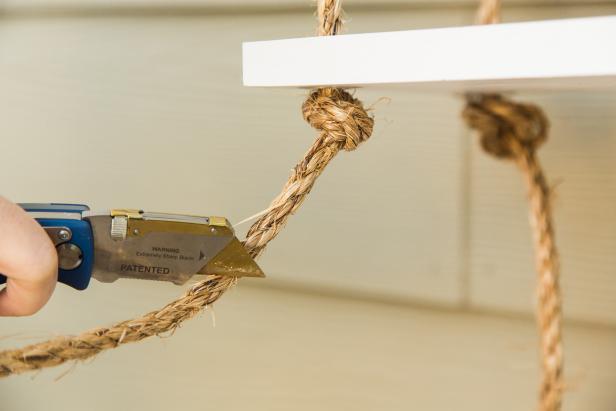 Once the bottom shelf is hung, tie off the ropes into a knot on either side, then trim them with a utility knife. For an interesting texture, you can pull apart the ends of the ropes for a fringed look. Now you’re ready to hang the shelf- just be sure to use the proper hardware and anchors! HINT- If you hang the shelf in a bathroom, over time the steam will help the rope straighten out a bit!