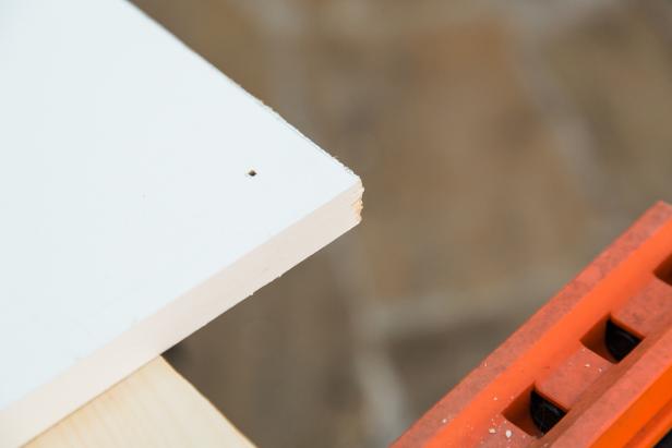 Next, flip the three boards over right side up and using the small hole as a guide, switch out the spade bit with a regular 3/8” drill bit and drill through. Repeat until all 12 holes are complete.