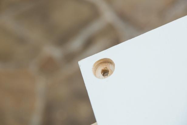 Next, flip the three boards over right side up and using the small hole as a guide, switch out the spade bit with a regular 3/8” drill bit and drill through. Repeat until all 12 holes are complete.