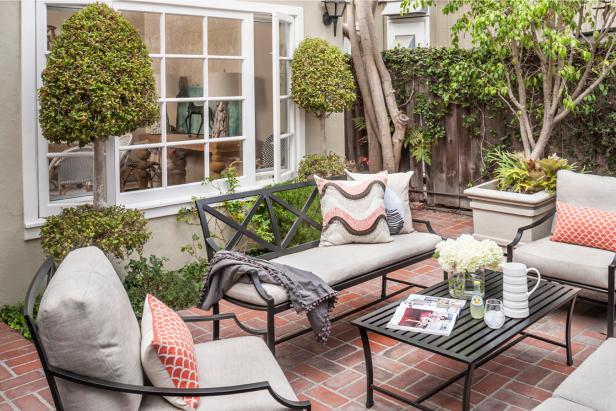 Black Iron Patio Furniture With Neutral Cushions and Fish Scale Throw Pillows on Brick Back Patio Black Iron Patio Furniture With Neutral Cushions and Fish Scale Throw Pillows on Brick Back Patio
