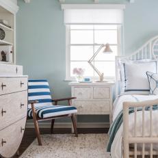 Airy Coastal Bedroom With Horseshoe Shaped Dresser, Pale Blue Walls, Exposed Ceiling Beams and Striped Chair 
