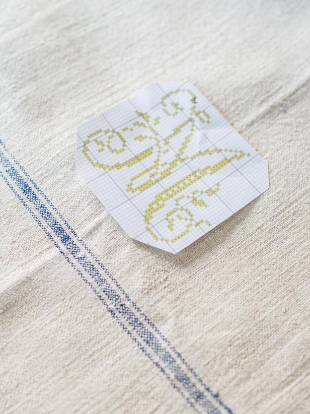 Step 1: Select Monogram PatternCross-stitch patterns can be purchased online or from a craft store, but many can also be found online for free. Position monogram pattern over tea towel to make sure the size and design will achieve the desired look. Pattern can be lightly sketched out with a pencil, if that is helpful but it is not a necessary step. Tip: A custom cross-stitch design can easily be created on graph paper.