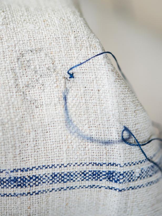 Step 3: Cross-stitch MonogramCreate X-shaped stitches on each square naturally created in the weave of the linen, following selected cross-stitch pattern. It is helpful if the fabric is starched or inserted in an embroidery hoop, so it is taut. Pull each stitch, so it is snug, but not too tight. Tip: Since this is a towel that can be seen from both sides, keep in mind how the back will look. Large pieces of thread running across the back have the potential of getting snagged.