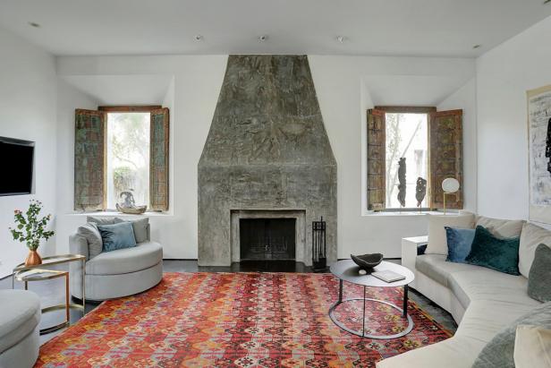 Spacious, Contemporary Living Room With Tall, Stone Fireplace Surround, Large Crescent Sofa and Warm Tone Pattern Rug Spacious, Contemporary Living Room With Tall, Stone Fireplace Surround, Large Crescent Sofa and Warm Tone Pattern Rug