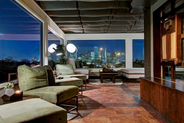 Dim, Stylish Dining Area With Skyline View, Plush Green Chairs and Red Stone Flooring Dim, Stylish Dining Area With Skyline View, Plush Green Chairs and Red Stone Flooring