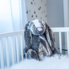 White Crib With Sheepskin Blanket In Nursery