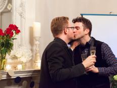 Gay Couple Kissing While Holding Champagne