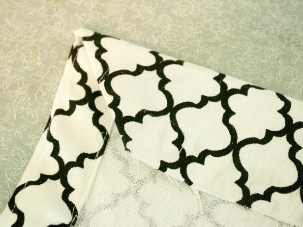 Fold in two inches and press all the way down the sides. Then, fold in again two inches, press, and stitch the fold twice in two parallel lines (top and bottom of folds) to reinforce it