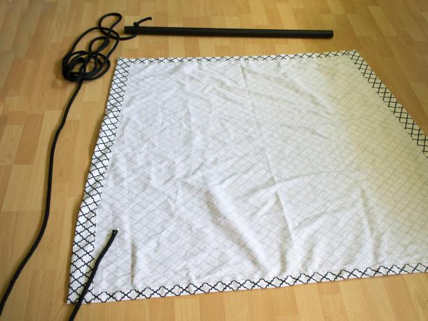 Guide the rope up from the widest corner of one side of the canvas seat to the narrow corner at the top.