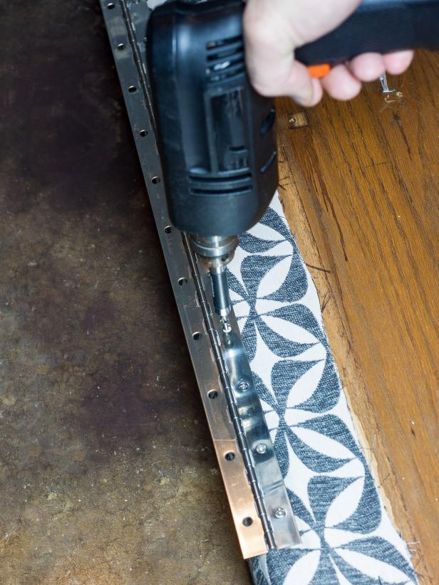 Add a piano hinge to one long edge of the ottoman top on the bottom side