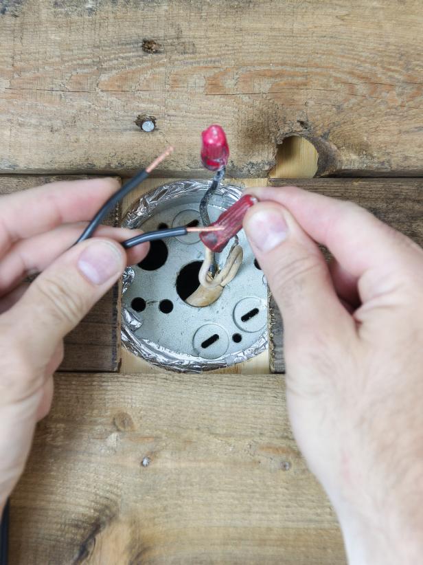 If using the galvanized hanger, feed the free end of the cord through the elbow, pipe and flange. Screw all of the pieces together. Pull the cord to the desired hanging length. Tie a knot in the cord to keep it from sliding. Remove excess wire. Split the end in half and remove 1/2" of coating from both sides. Twist the wires tightly between your fingers. Ensure that the power is turned off to your installation spot at the electrical panel, not the wall switch. Attach one side of the free cord to the white wire from the wall using a wire nut. Attach the other side of the cord to the black wire from the wall using a wire nut. Tuck the wires in the box apart from each other.