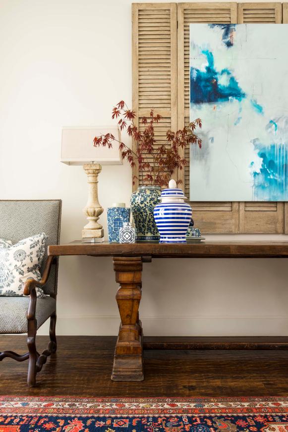 Tabletop Vase Display on Traditional Wood Table With Watercolor Painting Over Neutral Window Shutter Background Tabletop Vase Display on Traditional Wood Table With Watercolor Painting Over Neutral Window Shutter Background