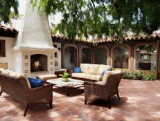 Mediterranean Brick Courtyard With Fireplace and Wicker Furniture
