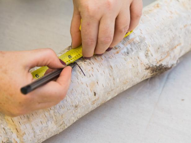 Determine the height of your vase and mark it on the log. Using a reciprocating saw, cut the log to size. Have someone hold the log in place as you cut to get a nice straight cut.