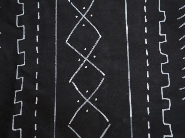The beauty of a mudcloth design is that it doesn’t need to be perfect. Using the white paint pen, freehand a design in rows. The yardstick is helpful in making lines down the length of the canvas. Repeat the pattern of rows across the whole fabric. Continue on the back if you get the urge and have enough paint pens