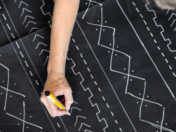 The beauty of a mudcloth design is that it doesn’t need to be perfect. Using the white paint pen, freehand a design in rows. The yardstick is helpful in making lines down the length of the canvas. Repeat the pattern of rows across the whole fabric. Continue on the back if you get the urge and have enough paint pens