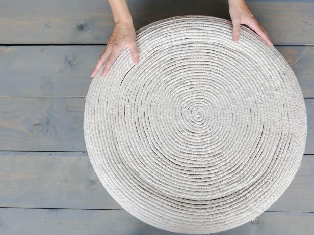 Starting on the top center of the circle, glue the clothesline in a tight spiral. Use a good amount of glue and try to not leave any gaps between the rope. Keep adding rope until it reaches the edge and continue down the sides of the tire. Flip the tire over and add rope until you cover the bottom side.