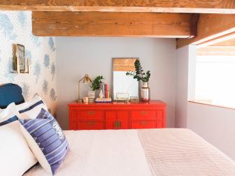 Eclectic Bedroom With Vibrant Red Dresser and Floral Wallpaper Accent Wall