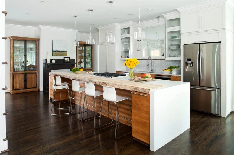 Designer Warm Modern Kitchen with Waterfall Edge Island, Mirror Over the Sink and Fireplace
