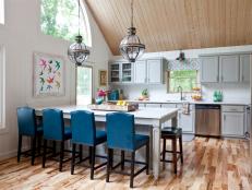 Vaulted Lakehouse Kitchen with White Walls, Gray Cabinets, Blue Chairs and Island