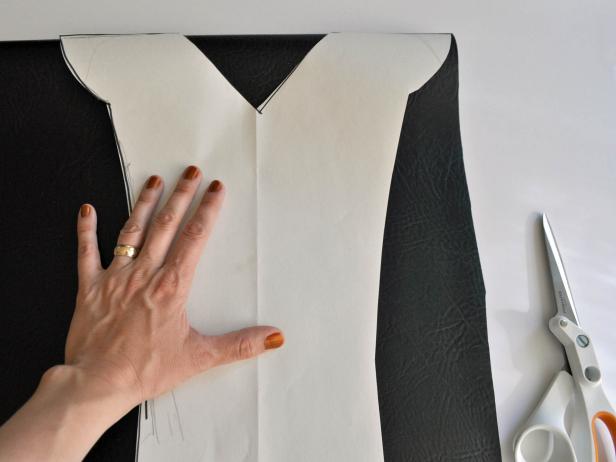 Fold synthetic leather in half and place pattern on leather with shoulders placed on the fold. Trace pattern onto leather. Cut out leather outline. Cut out head opening with a “V” in the front and rounded in the back making a raindrop-shape when armor is opened. Try on child and enlarge hole until the fit is correct. Outline edges of armor with 3-D fabric paint. Add additional lines to create visual interest. Cut two parallel diagonal slits across the back of the armor so that the sword can be slipped through.