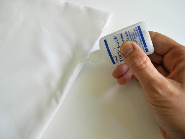 Invert pillowcase. Cut lines where shown. Seal cut edges of fabric to avoid fraying. To do so, melt edges over a flame. Do not put fabric in flame. Simply bring it close and watch it melt the edge. Edge will become slightly hardened and will not fray. Do not involve children in this process. Tip: If purchased pillowcase is not made of polyester or microfiber use Fray Check to prevent fraying instead. Squirt gently onto edges of fabric. Invert pillowcase and iron.