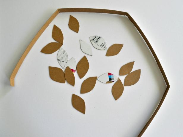 Cut open cereal box. Cut one long strip of cardboard and 20-25 leaves. Take cardboard strip and hold around head of the costume wearer to gauge size. Cut to length and use hot glue gun to glue ends together to create a headband. Hot glue leaves onto front half of the headband. Spray paint wreath gold.